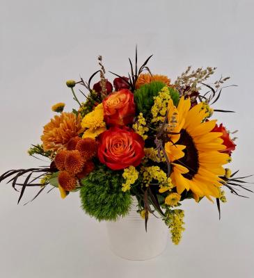 1 sunflower, 3 orange/yellow roses, 2 chrysanthmum and 2 green dianthus in a ceramic vase
